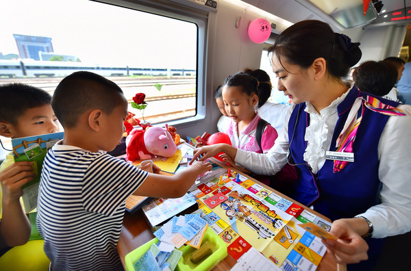 北京鐵路局天津客運段值乘的廈門北至北京南G324次列車乘務員與兒童旅客互動做游戲。