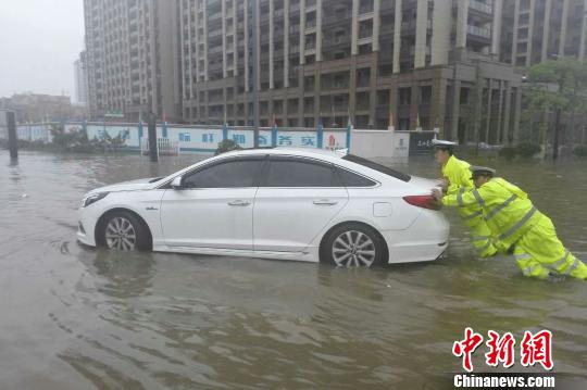 圖為：周宇和隊員在水中推拋錨的車。 金華公安供圖