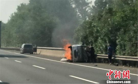 圖為：杭甬高速寧波段一輛面包車側翻后起火，好心人救一家7口。　何蔣勇 攝