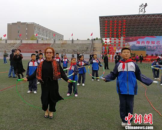 西班牙馬德里愛(ài)華中文學(xué)校校長(zhǎng)黃小捷饒有興致地與學(xué)生進(jìn)行跳繩比賽。　楊杰英 攝