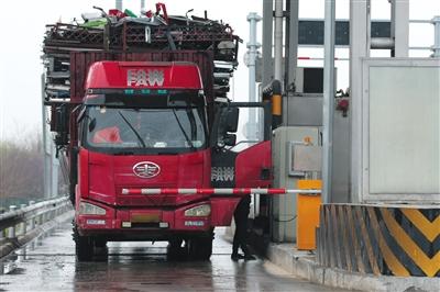 4月13日，京津高速臺湖收費站，一名大貨車司機從車上下來取高速卡。本版攝影/新京報記者 朱駿