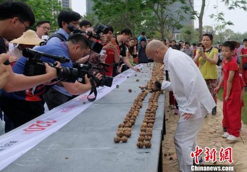 黎偉軍手劈核桃現場吸引不少人圍觀。　程景偉 攝