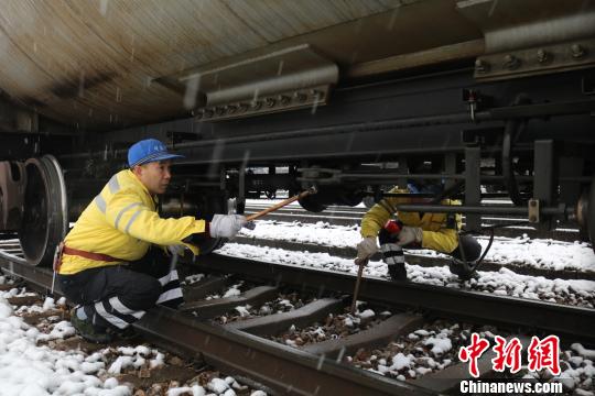 南京東車輛段貨車檢車員風雪里按標準作業(yè)，保障運輸安全。　劉寅 攝