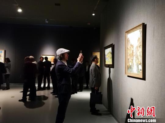 圖為，在“印象山東——俄羅斯油畫家寫生作品展”上，觀眾在喜歡的作品前駐足觀賞、拍照。　孫宏瑗 攝