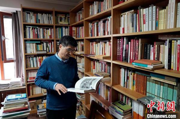 “家里能放書架的地方全部放著滿載的書架”。客廳、書房、走廊、臥室甚至陽臺都放滿了書。　趙彬 攝